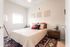 bedroom with large area rug and bed with white comforter and accent pillows