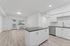 Kitchen and living area with wood-style flooring, stainless steel appliances and kitchen island.