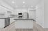 Kitchen with wood-style flooring, stainless steel appliances and kitchen island.