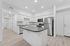 Kitchen with wood-style flooring, stainless steel appliances and kitchen island.