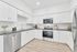 virtually staged kitchen with stainless steel appliances, white cabinets and grey countertops at Spring Meadow, in Newberg, OR