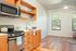 Kitchen and living area with original hardwood floors at Fairmount in Portland, OR