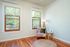 Living room with original hardwood flooring and wood-trimmed windows at Fairmount apartments in Portland, OR