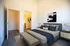 Apartments in Tigard, OR, with In-Unit Washer and Dryer - Pacific Ridge Apartments - Bedroom with Wood-Style Flooring, Large Bed, Bed Bench, Wall Art, Nightstands, Lamps, and Oversized Closet.