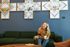 Woman on phone in Walden lobby with Native local art behind her
