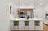 Midtown Phoenix, AZ, Luxury Apartments with In-Unit Washer and Dryer - Asa Midtown - A Sleek Kitchen with Island and Bar Seating, Stainless Steel Appliances, Wood Cabinetry, and Pendant Lighting.