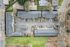 birds-eye-view showing entire property of apartments and parking and surrounding terrain.
