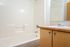 Bathtub, shower, and countertop with sink and mirror.