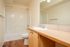Bathtub, shower, and long shot of countertop with sink and mirror.