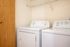 Laundry area with washer and drier and rack above.