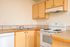 Kitchen with sink, oven, stove, dishwasher, countertops, and ventilation.