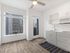 Studio kitchen with white cabinetry and large windows at Koz on 4th.