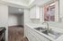 Kitchen with sink, window, stairway, and wooded entrance