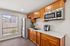 Community kitchen with refridgerator, microwave, window view and wooden counters and cupboards