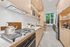 artisan kitchen view showing stove fridge and storage