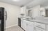 view 2 of kitchen in B1 renovated floorplan at Timber Flats white cabinets black appliances and grey countertops