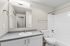 bathroom in B1 renovated floorplan at Timber Flats shower with tub and grey countertops white cabinets