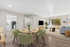 virtually staged dining room at Bridge Lane with dining table and chairs and showing view into living room