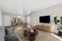 virtually staged living room at Bridge Lane with a couch, coffee table, tv, console and plant and showing view into dining room