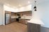 Kitchen at Orrin with a L shaped counter, white counter and wood cabinets and flooring