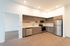 Kitchen at Orrin L shaped with wood flooring and wood cabinets and white countertops