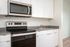 Closeup of kitchen at Lyra apartments with grey countertops and stainless steel appliances