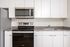 Closeup of kitchen at Lyra apartments with grey countertops and stainless steel appliances