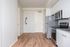 Kitchen and entryway at Lyra apartments with grey countertops and stainless steel appliances
