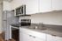 Closeup of kitchen at Lyra apartments with grey countertops and stainless steel appliances