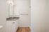 One Bedroom at Lyra Apartments - Bathroom with grey counter and hardwood floorps