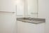 One-Bedroom at Lyra Apartments - bathroom with grey counter and sink with mirror