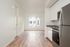 One-Bedroom at Lyra Apartments - view from the kitchen into the living room with stainless steel appliances and hardwood floors