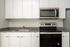 One-Bedroom at Lyra Apartments - closeup of kitchen with grey countertops and stainless steel appliances