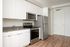 One-Bedroom at Lyra Apartments - closeup of kitchen with grey countertops and stainless steel appliances