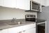 One-Bedroom at Lyra Apartments - closeup of kitchen with grey countertops and stainless steel appliances