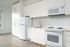 Cassi Apartments - kitchen with white appliances and white countertops and cabinets