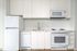 Cassi Apartments - kitchen with white appliances and white countertops and cabinets