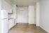 Cassi Apartments - kitchen with white appliances and white countertops and cabinets and view to the front door entryway