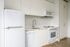 Cassi Apartments - kitchen with white appliances and white countertops and cabinets