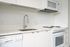 Cassi Apartments - kitchen with white appliances and white countertops and cabinets