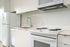 Cassi Apartments - kitchen with white appliances and white countertops and cabinets