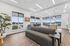 The community room at Orrin with a couch area, kitchenette, large windows and a foosball table