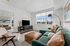 Orrin Apartments living room with wood floors and white walls, a couch, chair, tv and ottoman