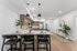 Orrin Apartments kitchen interior with wood cabinets and wood floors, white counters and backsplash and barstool seating