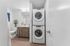 Bathroom at Orrin with a stacking washer and dryer, white appliances, wood floors and white countertops