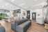 The community room at Orrin with a couch area, kitchenette, large windows and a foosball table