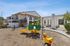 Playground with apartments, community area seating, and blue sky.