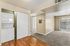 Living area with laundry, wooden floor, carpet, patio, and hallway.