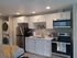 Modern kitchen with white cabinets and dark counters at Lakeside Place.