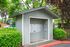 Mailbox shed with trees and bushes.